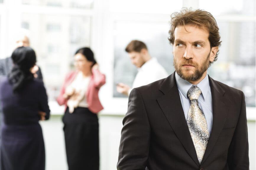 worker looks suspicious while coworkers chat in background