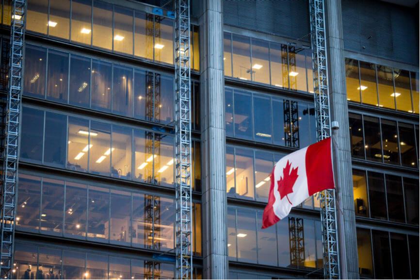 canadian flag waves in front of office building