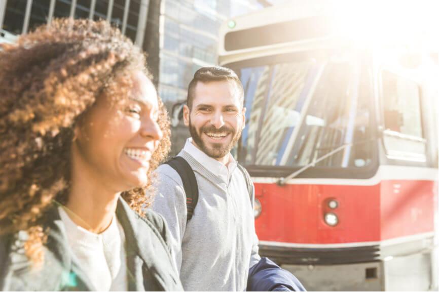 two canadian commuters walk in front of a toronto streetcar