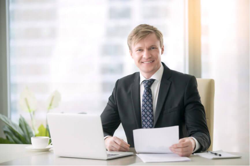 executive holds a resume at their desk