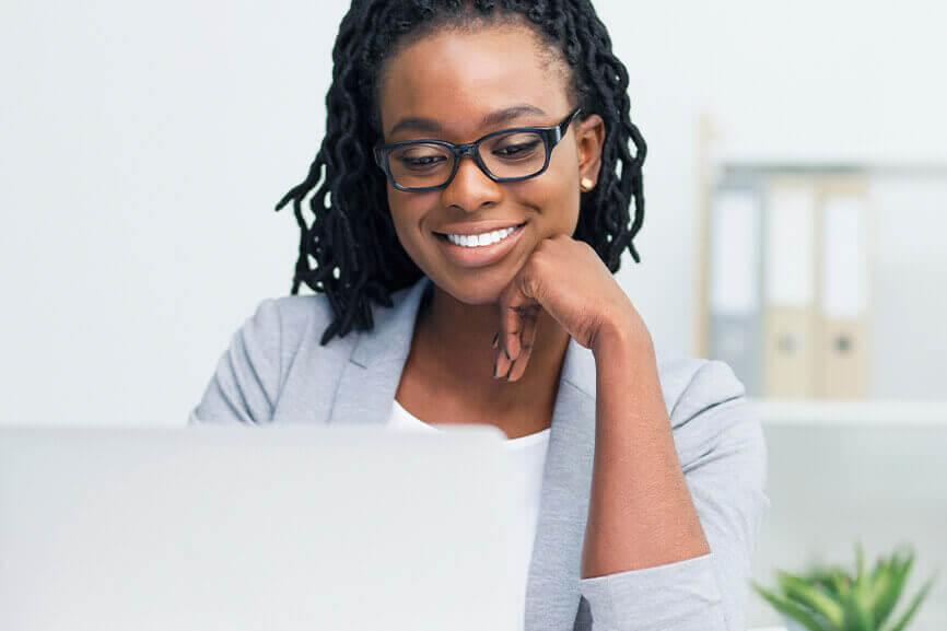 Woman smiling happily in front of laptop