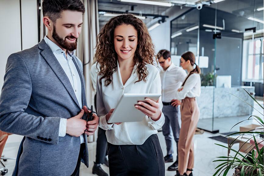 Woman looking at her tablet with her male coworker in the office