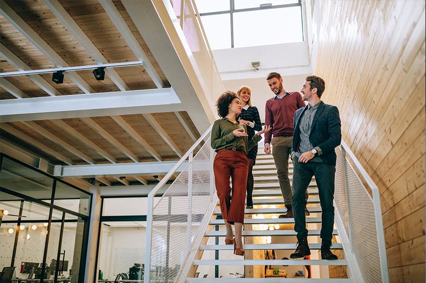 A group of coworkers walking down the stairs at work