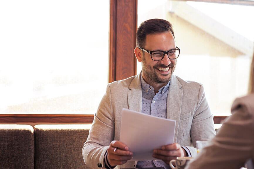 Man happily smiling while holding documents