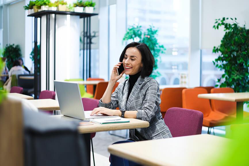 Woman on the phone while looking at laptop