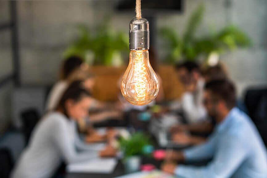 Lightbulb in a meeting room full of coworkers