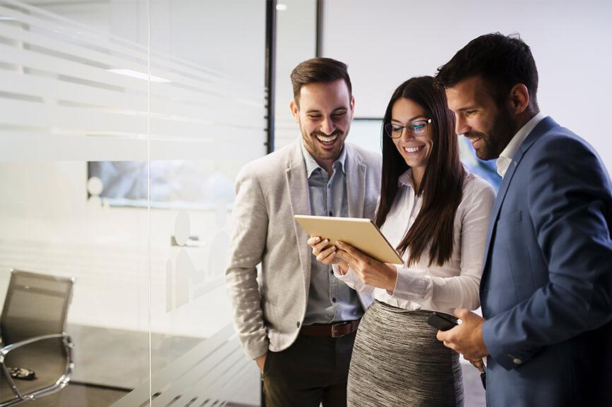 Three coworkers looking at tablet screen