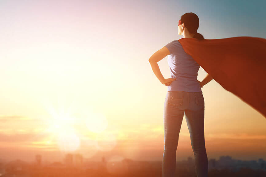 Woman in superhero costume looking out at the city