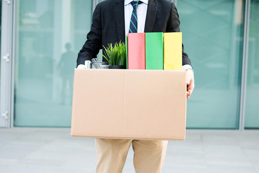 Man walking with his office things in a box