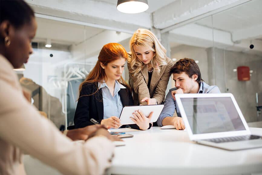 A group of people looking at a tablet together at work