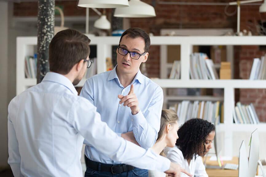 Man pointing fingers at coworker in the office