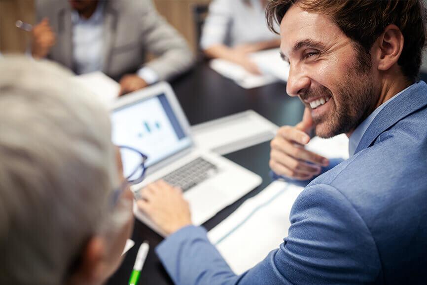 Man talking to his coworker while his laptop is opened