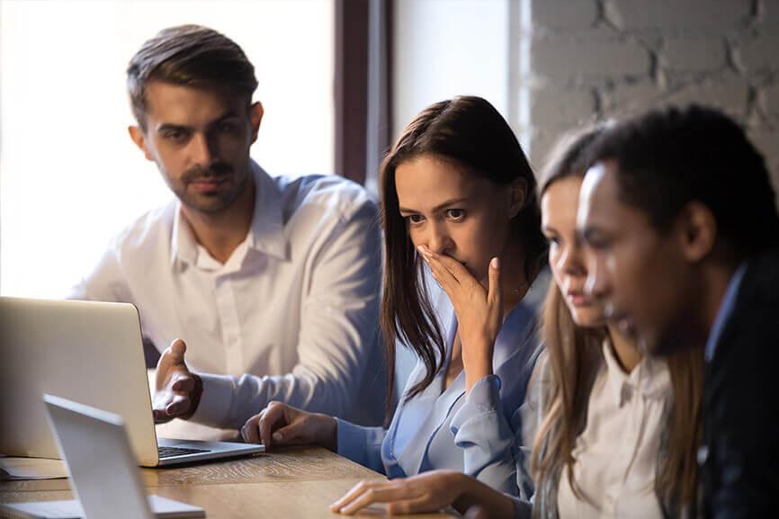 Employees looking worried while looking at laptop screen