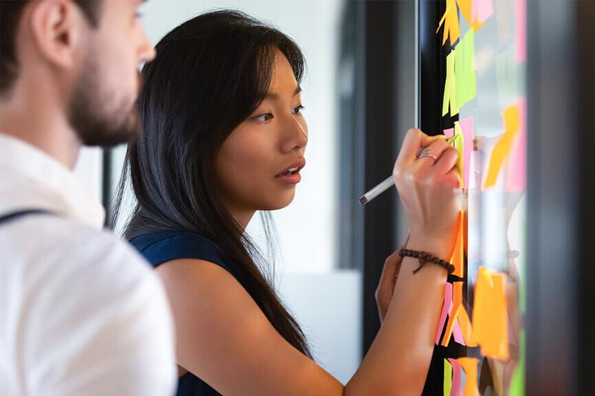 Woman writing on sticky notes