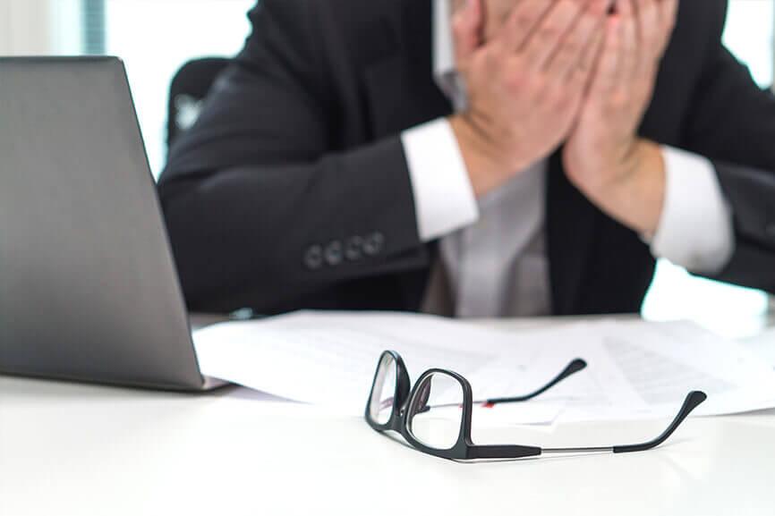 Man with his face in his hands looking frustrated