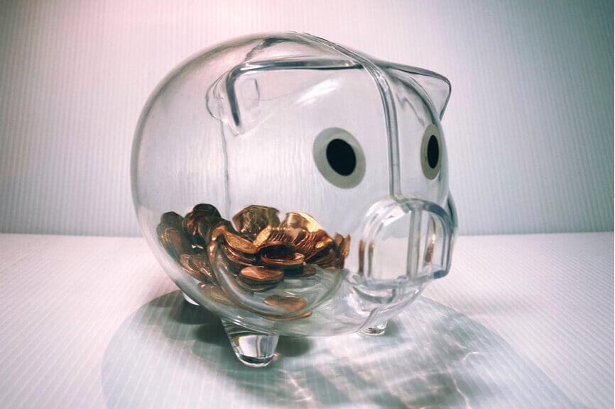 A see-through piggy bank that contains pennies