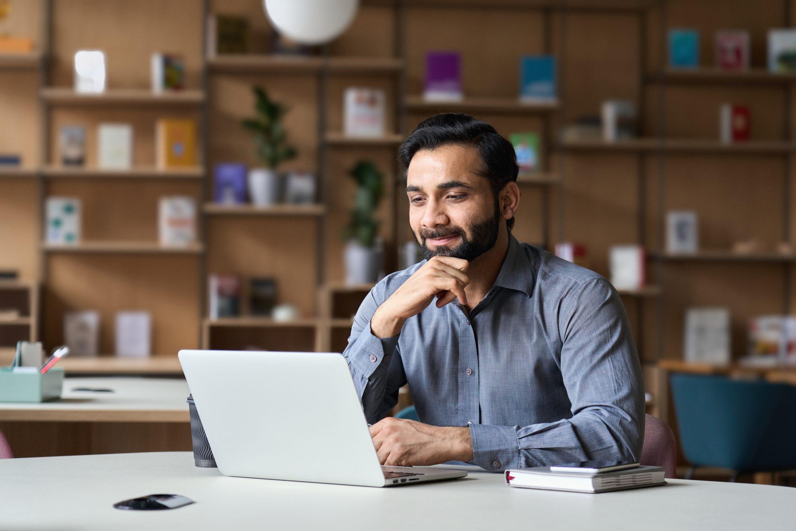 Man Gladly Looking At His Computer At The Office