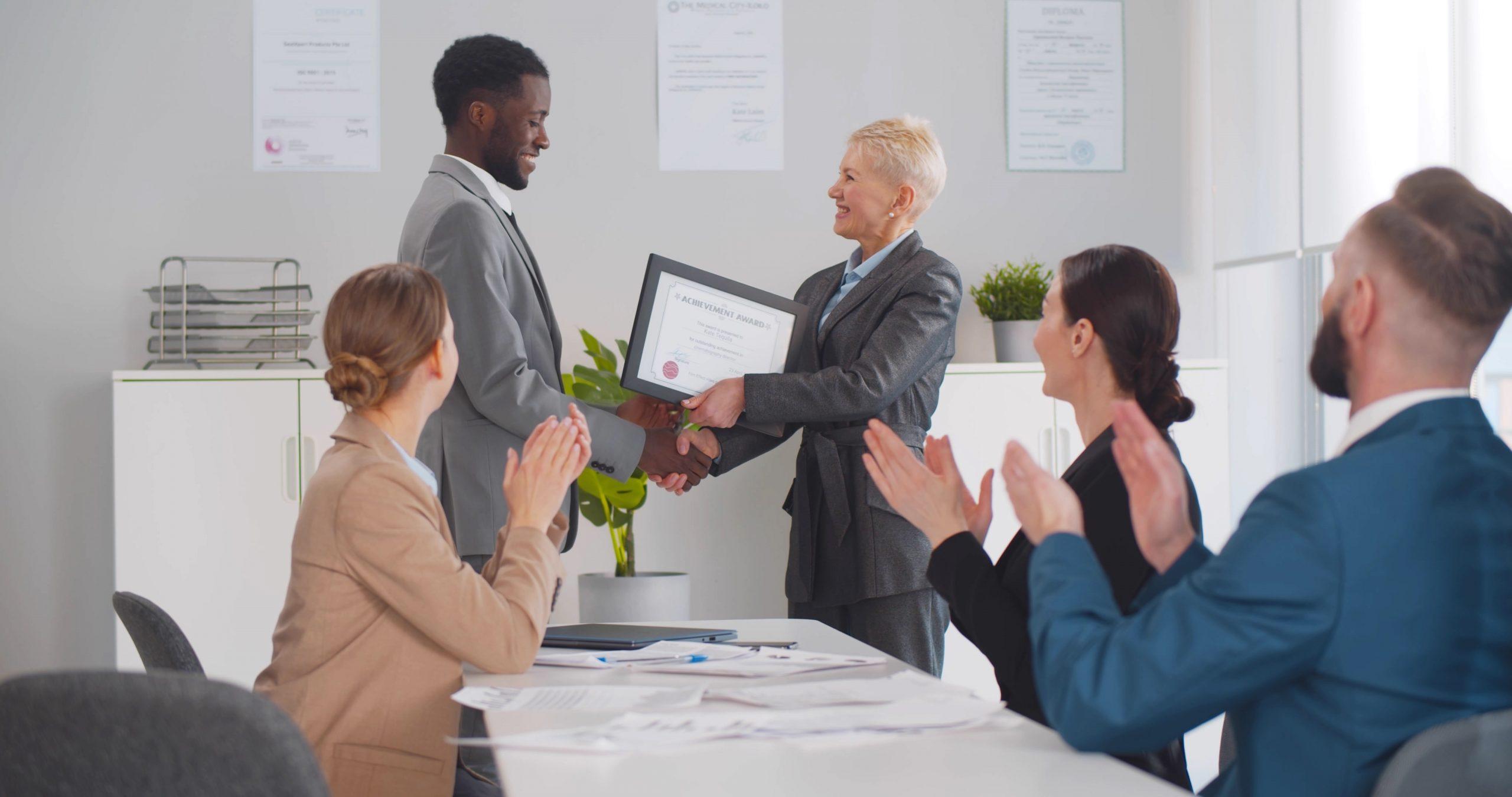 Person receiving certificate in front of peers.